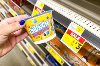 hand holding up a cap'n crunch cereal cup