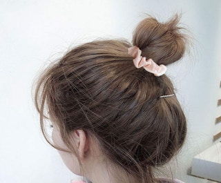 a pink scrunchie in someone's hair
