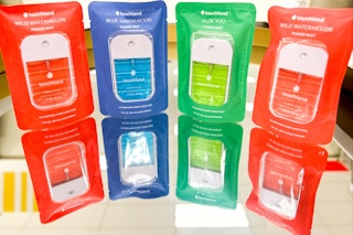 4 Touchland Hand Sanitizers in different scents with their reflection in mirror