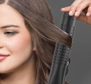 a person using a air flat iron on their hair 