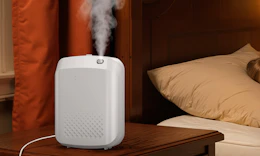 an essential oil diffuser on wooden nightstand in a room