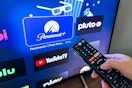 Someone holding a remote, pointing it at the screen to open the Paramount Plus app on their tv