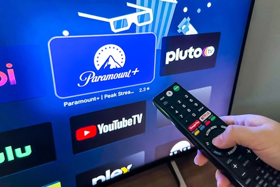 Someone holding a remote, pointing it at the screen to open the Paramount Plus app on their tv