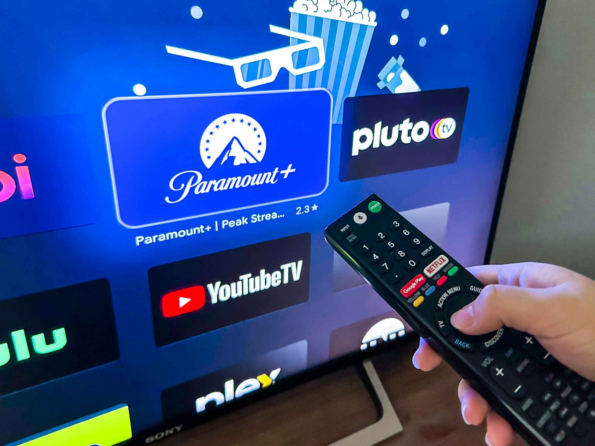 Someone holding a remote, pointing it at the screen to open the Paramount Plus app on their tv