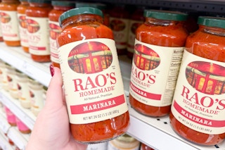 person grabbing a jar of rao's marinara sauce off the shelf