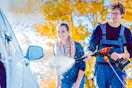 Lifestyle image of a Nexpow Cordless Pressure Washer being used by two adults to wash a car