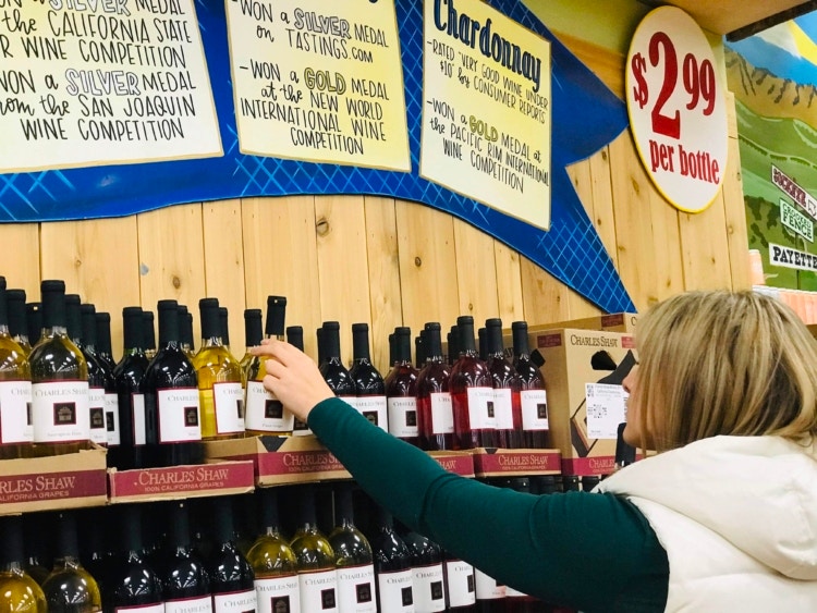 Person pulling white wine from a store shelf