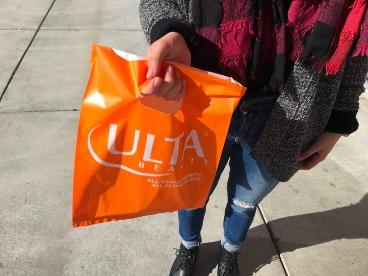 Person holding orange Ulta shopping bag