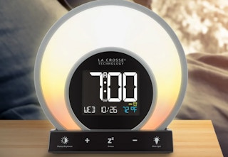 a glowing circular sunrise alarm clock sitting on a side table