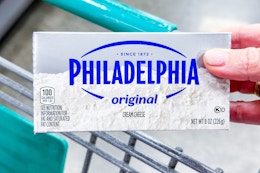 hand holding a block of philadelphia cream cheese