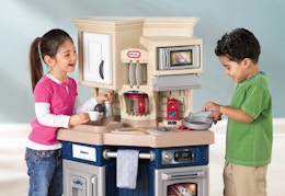 children playing with the tan and blue Little Tikes play kitchen