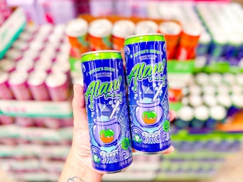 person holding 2 alani witch's brew energy drinks