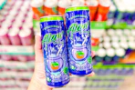 hand holding cans of alani new witches brew
