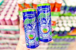 hand holding cans of alani new witches brew