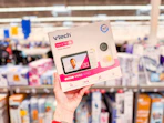 hand holding up box for v tech baby monitor in a store