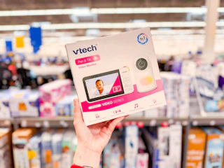 hand holding up box for v tech baby monitor in a store