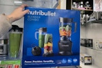 a hand on a box with a blender set on the front