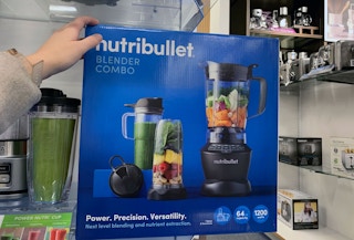 a hand on a box with a blender set on the front
