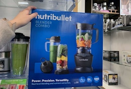 a hand on a box with a blender set on the front