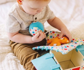 a baby playing with toys in a box