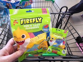 person holding a bag of baby shark flossers over a cart