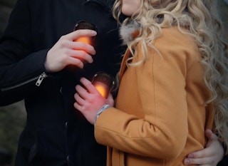a woman and man holding hand warmers