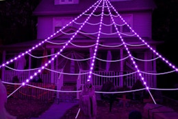 purple spider web lights glowing in front of house