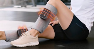 a person sitting with leg massager