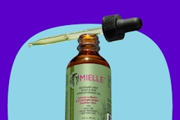 Mielle Organics Rosemary & Mint Hair Oil on a blue background.