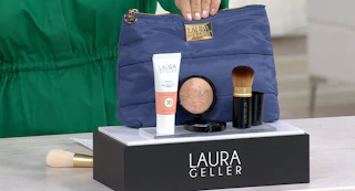 Laura Geller makeup next to a cosmetics bag on a display