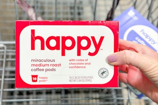 hand holding a box of happy coffee pods