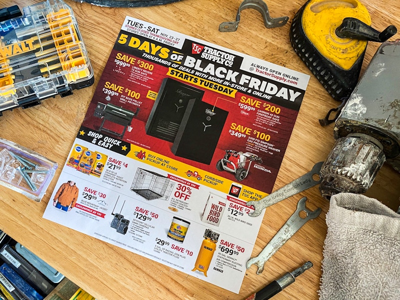 A Tractor Supply Co 2021 Black Friday ad sitting on a work bench surrounded by tools.