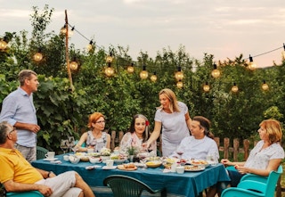 a family sitting outside under outdoor string lights