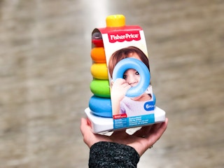 a hand holding a colorful stacking toy