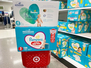 Two boxes of Pampers diapers stacked on top of a Target shopping cart