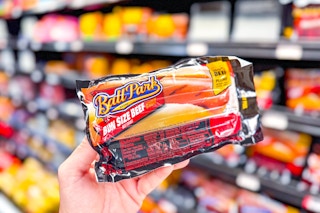 person holding a package of ball park franks