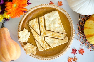 A pumpkin pie with the KCL icon baked into it surrounded by fall decor