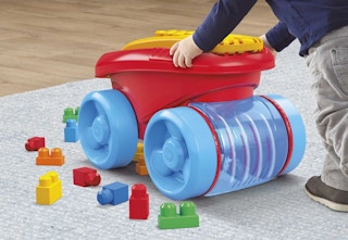 a child pushing a red and blue Mega Bloks wagon