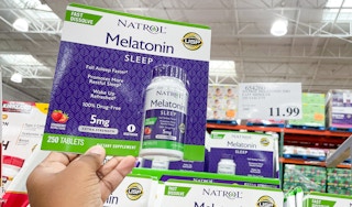 melatonin hand held near sale sign at costco