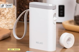 a white and grey label maker next to a roll of tape and labels