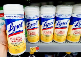 Lysol Disinfecting Wipes held in front of display at Walmart. Sticker on shelf indicates the price is $2.97 per container.