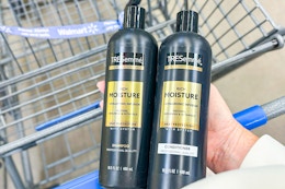hand holding two bottles of Tresemme shampoo and conditioner