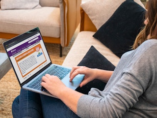 A woman looking at the Valore book rental website on her laptop