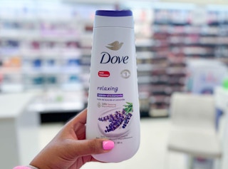hand holding Dove body wash bottle