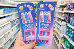 hand hodling two packs of schick touch up razors