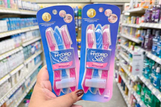 hand hodling two packs of schick touch up razors