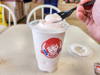 Someone taking a scoop from a Wendy's strawberry frosty