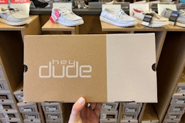 in store hey dude shoe box held up infront of hey dude shoe display