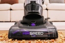 Lifesyle image of the Eureka Airspeed Vacuum being used to clean up crumbs on the floor