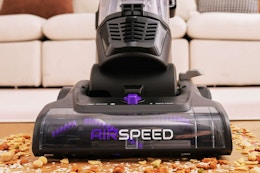 Lifesyle image of the Eureka Airspeed Vacuum being used to clean up crumbs on the floor